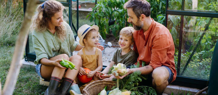 familie sitzt im garten erntet gemuese 1700x740
